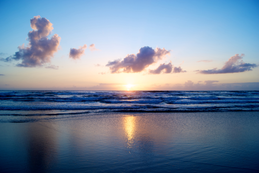 A view of the sun rising over the ocean